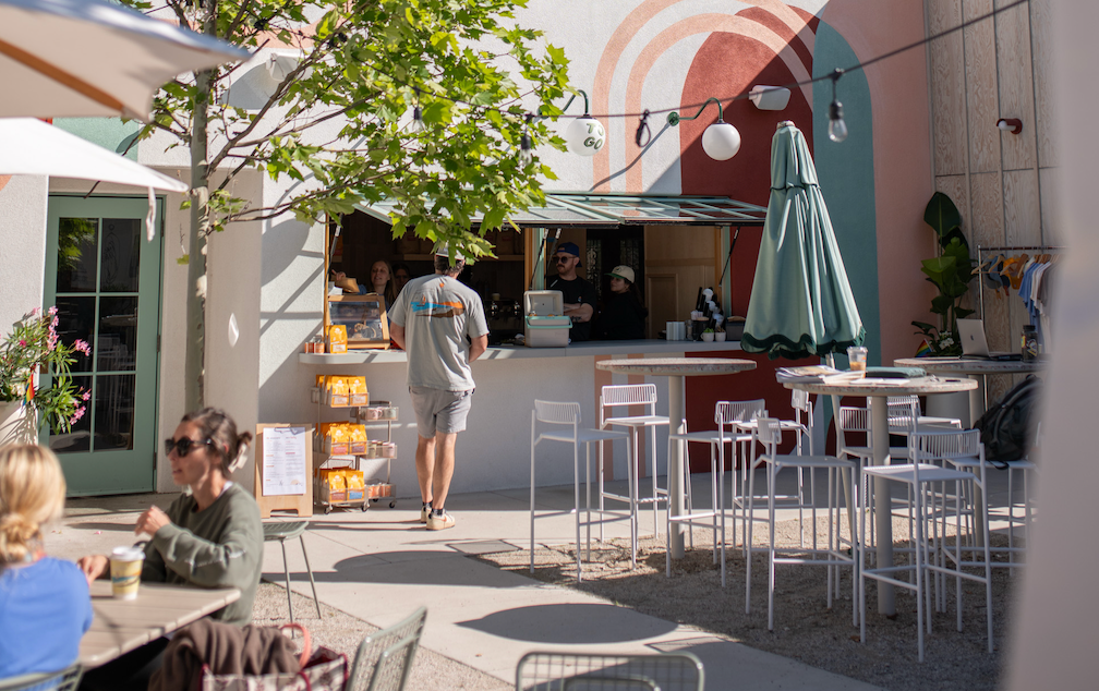 Outdoor cafe in New Buffalo, Michigan serving Infusco coffee with tables, chairs, and people enjoying the patio. 
